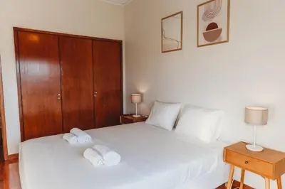 a bedroom with a white bed with two towels on it at Apartamento Santos Pousada 2 in Porto