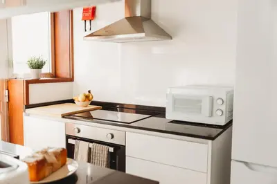 a kitchen with a sink and a microwave at Apartamento Santos Pousada 2 in Porto