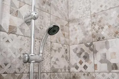 a shower with a shower head in a bathroom at PortoNest Downtown Suites in Porto
