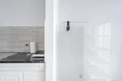 a kitchen with white walls and a white door at PortoNest Downtown Suites in Porto