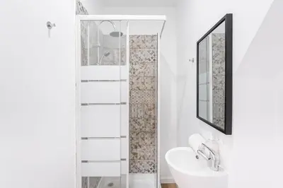 a white bathroom with a sink and a mirror at PortoNest Downtown Suites in Porto