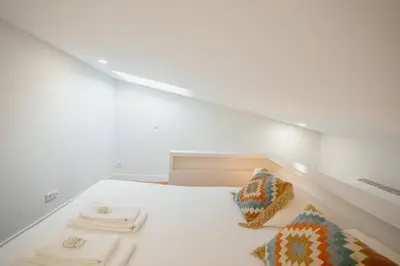 a white room with a bed with two pillows at Lapa Cozy by Hosty in Porto