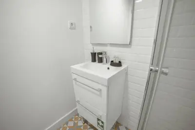 a white bathroom with a sink and a mirror at Lapa Cozy by Hosty in Porto