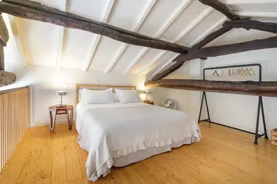a bedroom with a white bed and wooden floors at Fly me to the Moon in Porto