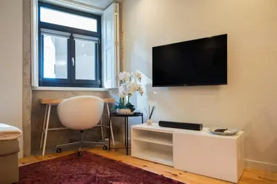 a living room with a flat screen tv on the wall at Cosy House Downtown Porto with swimming pool and AC in Porto