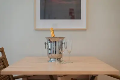 a blender on a wooden table with two wine glasses at Cosy House Downtown Porto with swimming pool and AC in Porto