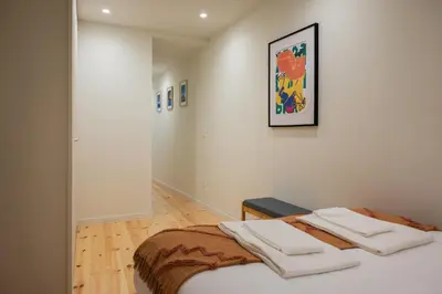 a white room with a bed with towels on it at Cosy House Downtown Porto with swimming pool and AC in Porto