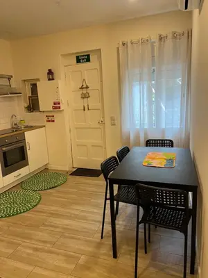 a kitchen with a table and chairs and a door at River Place in Porto