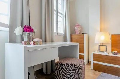 a white desk with flowers on it in a room at Stunning Clerigos Duplex apartment in the heart of Porto in Porto