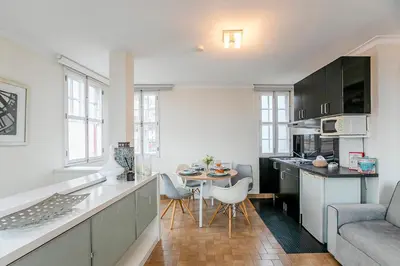 a kitchen and living room with a table and a couch at Stunning Clerigos Duplex apartment in the heart of Porto in Porto