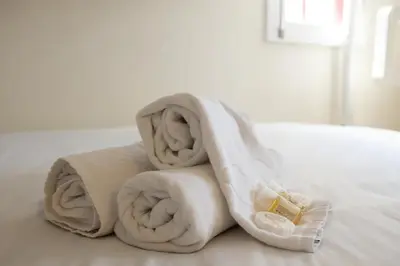 a pile of towels sitting on top of a bed at Clerigos Studio Apts in Porto