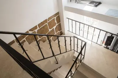 a staircase in a house with a stone wall at Clerigos Studio Apts in Porto