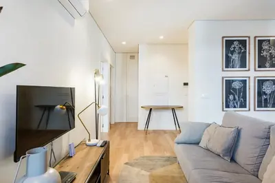 a living room with a couch and a flat screen tv at GuestReady - A secret passage in Porto in Porto