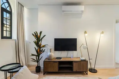a living room with a tv on a white wall at GuestReady - A secret passage in Porto in Porto