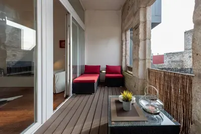 a balcony with red chairs and a table at Fontainhas Flat: Balcony & Parking in Porto