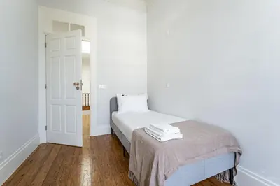 a white bedroom with a bed and a white door at Nomad's Family - 3BDR Charming Hideouts Porto in Porto