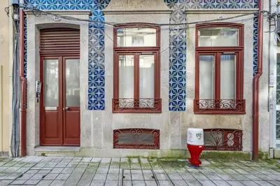 a building with a red door and two windows at Nomad's Lux - 1BDR The Silent Nest in Bonfim in Porto