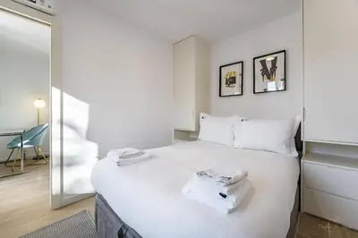 a bedroom with a large white bed with a mirror at Nomad's Lux - 1BDR The Silent Nest in Bonfim in Porto