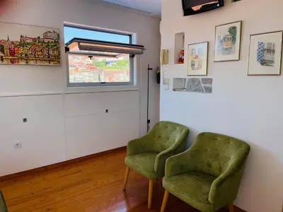 two green chairs in a room with a window at Douro River Apartments in Vila Nova de Gaia