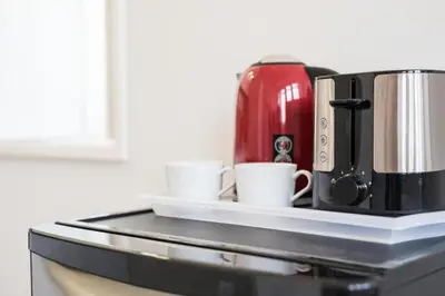 a coffee maker and two cups on a counter at Frei Yellow Studio in Porto