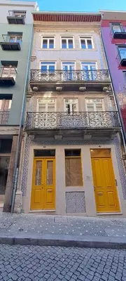 a building with orange and yellow doors on a street at ALMARELA apartments in Porto