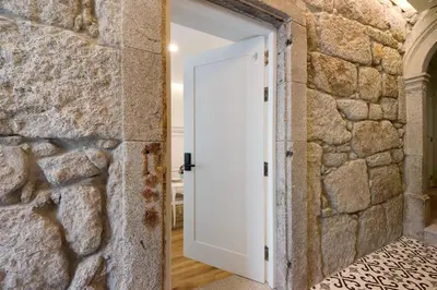 a white door in a stone wall with a brick wall at Porto Bello - Apartamento -1 in Porto