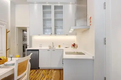 a white kitchen with a sink and a table at Porto Bello - Apartamento -1 in Porto