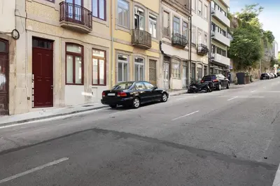 a black car parked on the side of a city street at Porto Bello - Apartamento - 2 in Porto