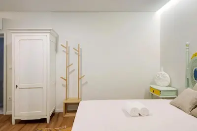 a bedroom with a white bed with two towels on it at Porto Bello - Apartamento - 2 in Porto