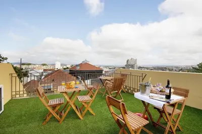 a patio with tables and chairs on a roof at Porto Bello - Apartamento - 3 in Porto