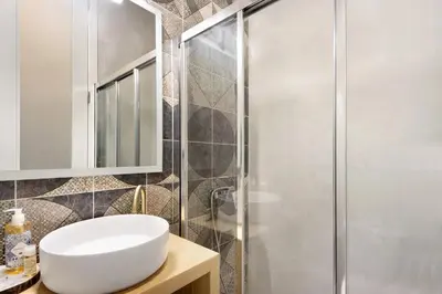 a bathroom with a white sink and a shower at Porto Bello - Apartamento - 4 in Porto