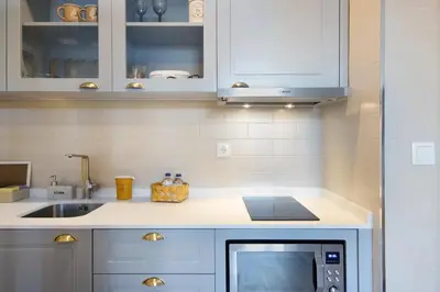 a kitchen with white cabinets and a microwave at Porto Bello - Apartamento - 5 in Porto