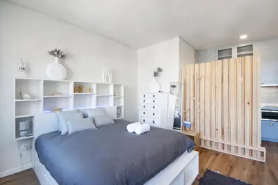 a bedroom with a large bed and white walls at Porto Bello - Apartamento - 5 in Porto