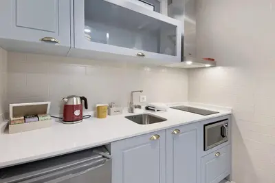 a white kitchen with a sink and a counter top at Porto Bello - Apartamento - 6 in Porto