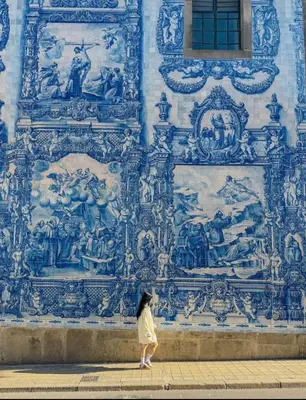 a woman walking past a mural on a wall at Porto Bello - Apartamento - 6 in Porto