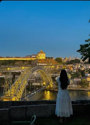 a woman in a white dress looking at a bridge at Porto Bello - Apartamento - 8 in Porto