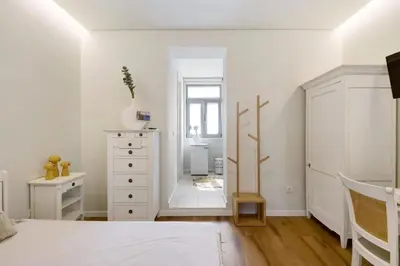 a white bedroom with a dresser and a mirror at Porto Bello - Apartamento - 8 in Porto