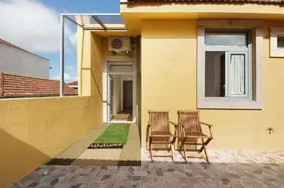 two chairs and a table on the side of a house at Porto Bello - Apartamento - 8 in Porto