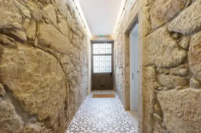 a hallway with a stone wall and a door at Porto Bello - Apartamento - 8 in Porto