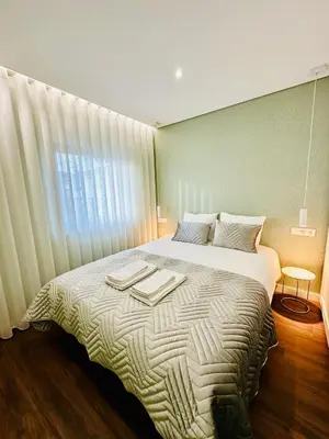 a bedroom with a bed with two towels on it at House Real Companhia 55/53 in Vila Nova de Gaia