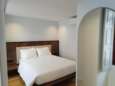 a bedroom with a white bed and a mirror at Almada 505 City Center Duplex in Porto