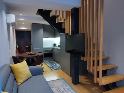 a living room with a blue couch and a television at Almada 505 City Center Duplex in Porto