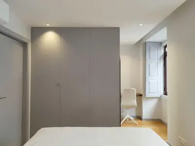 a bedroom with a white bed and a chair at Almada 505 City Center Duplex in Porto