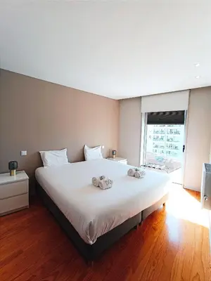 a bedroom with a large bed with two towels on it at BO - Aníbal Cunha in Porto