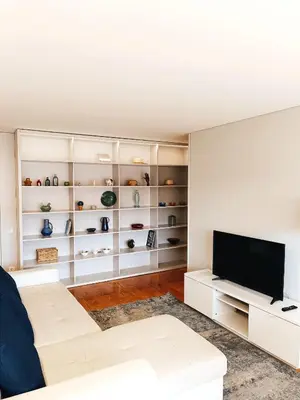 a living room with white furniture and a flat screen tv at BO - Aníbal Cunha in Porto