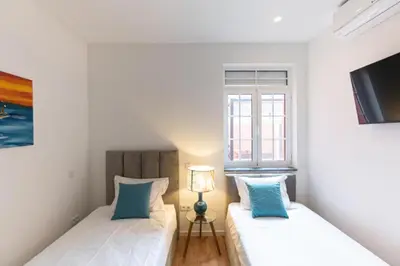 two beds in a small room with a window at Dellarose Max in Porto