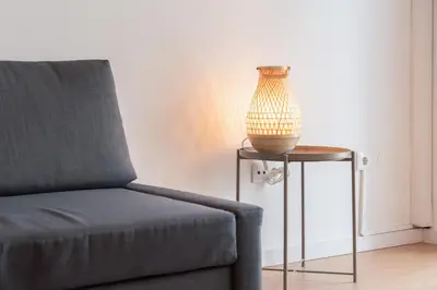 a lamp sitting on a table next to a chair at Host Wise - Spacious Modern Flat w Balcony in Porto
