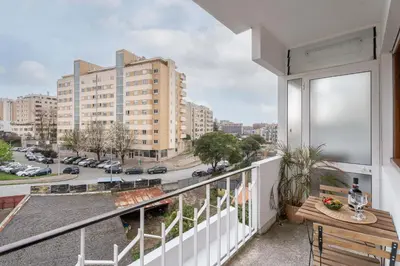a balcony with a table and a view of a city at Host Wise - Spacious Modern Flat w Balcony in Porto