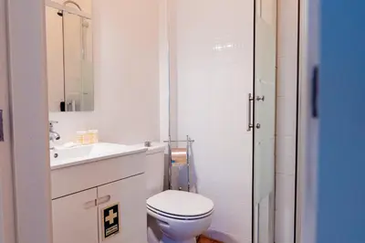 a white bathroom with a toilet and a sink at Emotions Trindade Flat in Porto