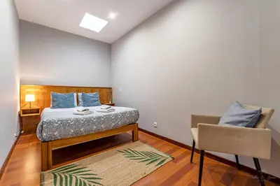 a bedroom with a bed and a chair at Experience the Charm Porto Apartment with Terrace in Porto